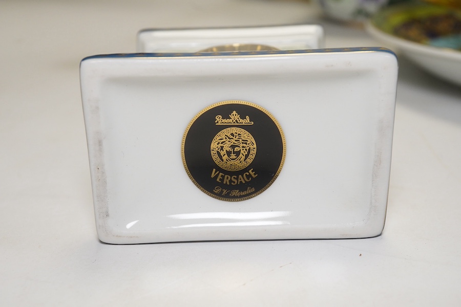 Six Rosenthal for Versace porcelain items; a boxed chocolate cup and saucer, four oblong serving dishes, longest 23cm, and a boxed miniature timepiece, 8.5cm high. Condition - good.